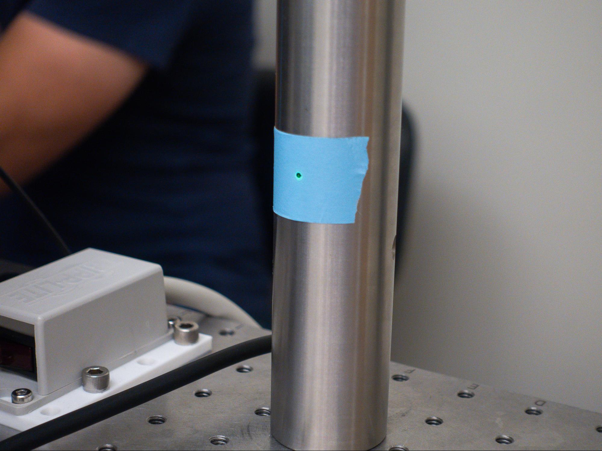 A laser spot on a post, marked with a pen